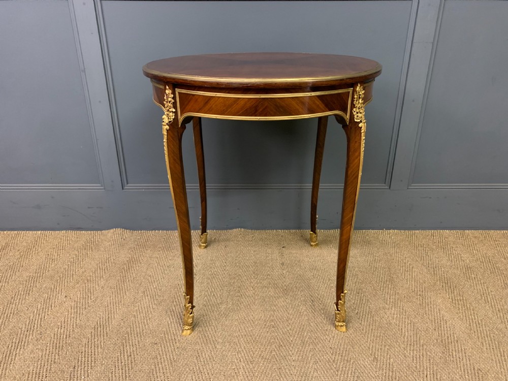 A circular French Louis XV revival centre table featuring quartered rosewood veneers, brass moulding rim, and gilt-bronze mounts on cabriole legs. View II