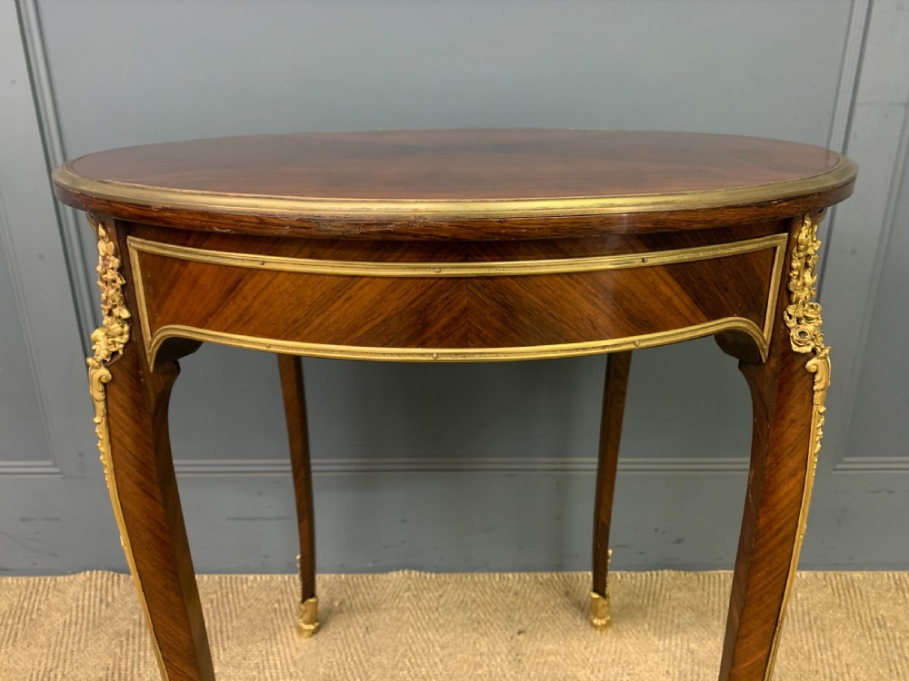 A circular French Louis XV revival centre table featuring quartered rosewood veneers, brass moulding rim, and gilt-bronze mounts on cabriole legs. View V
