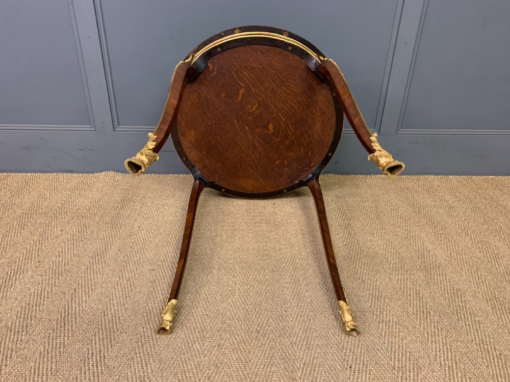 A circular French Louis XV revival centre table featuring quartered rosewood veneers, brass moulding rim, and gilt-bronze mounts on cabriole legs. View IX