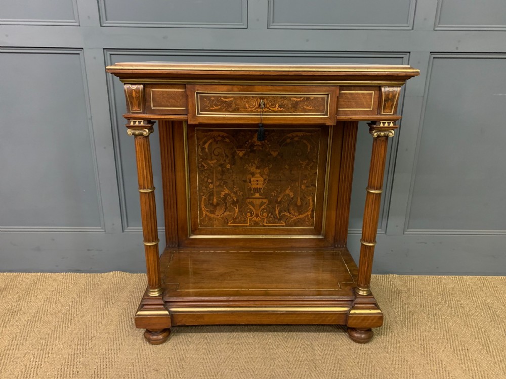 A 19th-century walnut pier table featuring a white marble top, inlaid floral and urn marquetry, fluted front columns with gilt mounts, and a lower open shelf. View II