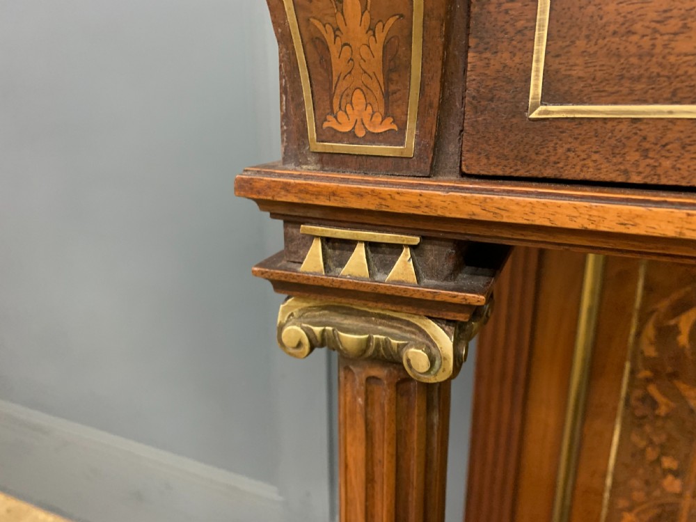 A 19th-century walnut pier table featuring a white marble top, inlaid floral and urn marquetry, fluted front columns with gilt mounts, and a lower open shelf. View X