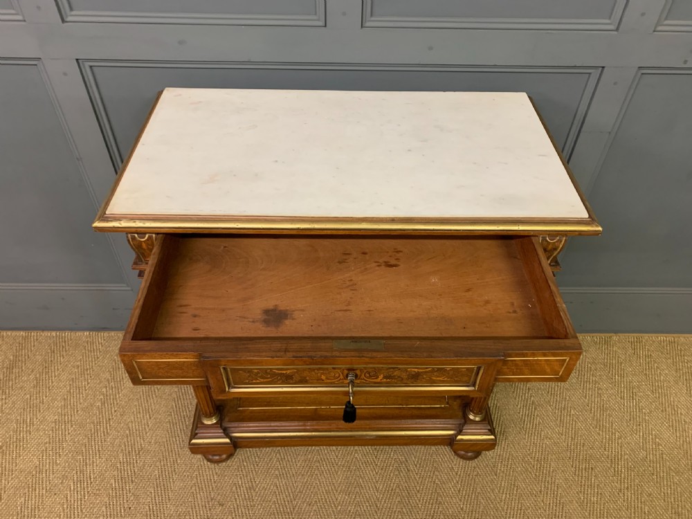A 19th-century walnut pier table featuring a white marble top, inlaid floral and urn marquetry, fluted front columns with gilt mounts, and a lower open shelf. View XII