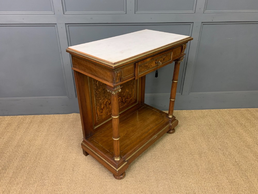 A 19th-century walnut pier table featuring a white marble top, inlaid floral and urn marquetry, fluted front columns with gilt mounts, and a lower open shelf. View XIII