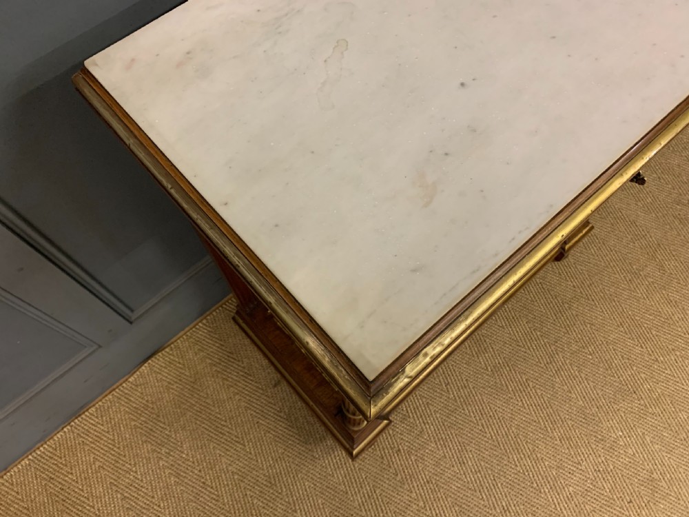 A 19th-century walnut pier table featuring a white marble top, inlaid floral and urn marquetry, fluted front columns with gilt mounts, and a lower open shelf. View XX