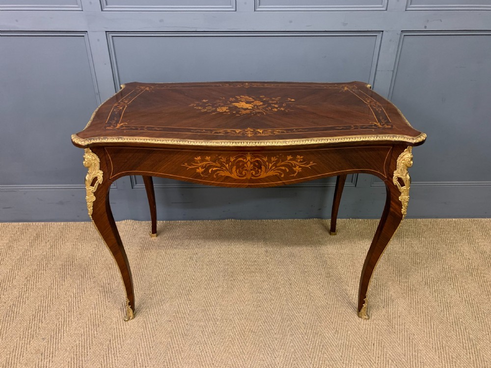 An antique rosewood occasional table featuring floral marquetry inlays across the serpentine top and apron, supported by cabriole legs with gilt-bronze ormolu mounts.