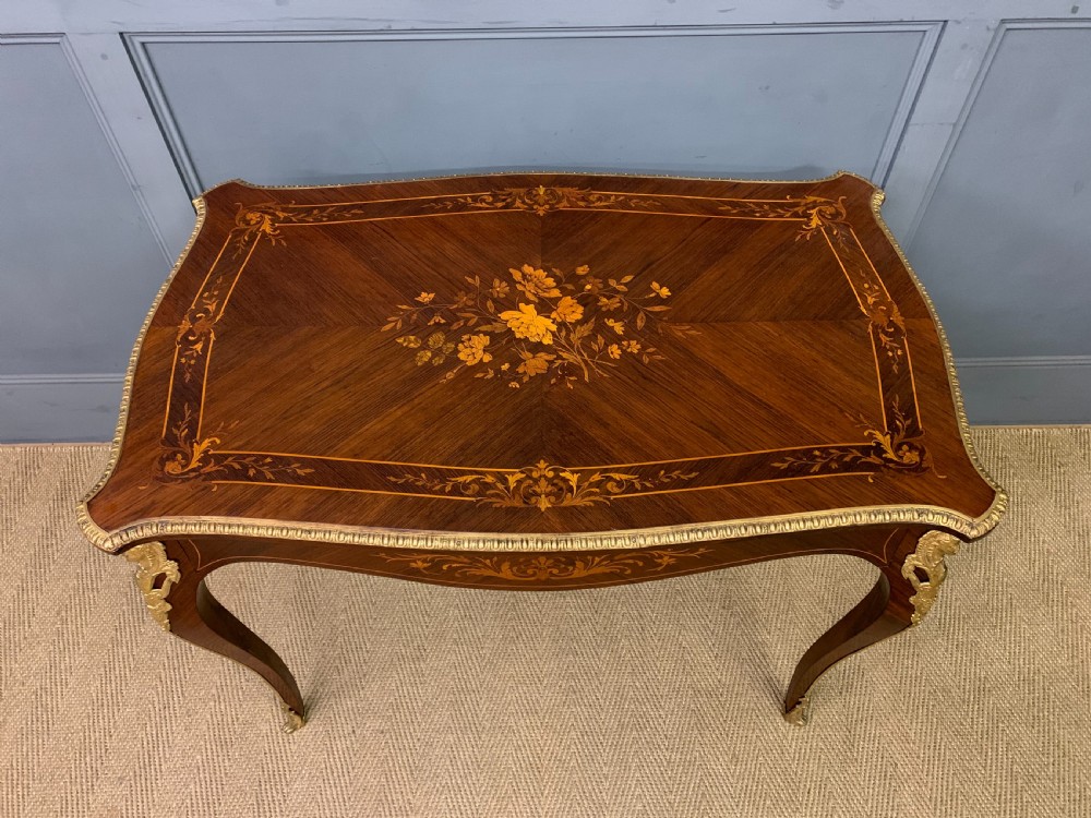An antique rosewood occasional table featuring floral marquetry inlays across the serpentine top and apron, supported by cabriole legs with gilt-bronze ormolu mounts. View III