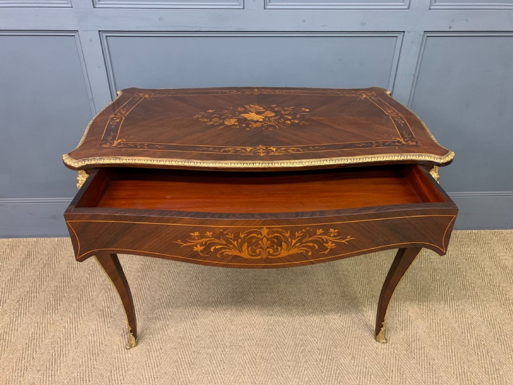 An antique rosewood occasional table featuring floral marquetry inlays across the serpentine top and apron, supported by cabriole legs with gilt-bronze ormolu mounts. View V