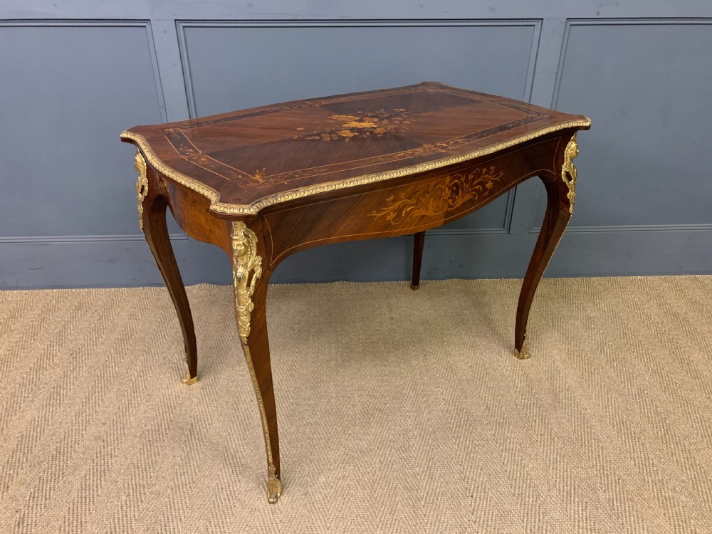 An antique rosewood occasional table featuring floral marquetry inlays across the serpentine top and apron, supported by cabriole legs with gilt-bronze ormolu mounts. View VI