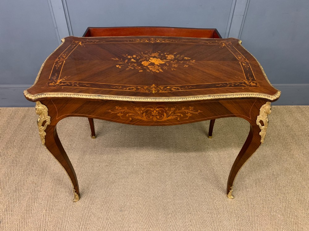 An antique rosewood occasional table featuring floral marquetry inlays across the serpentine top and apron, supported by cabriole legs with gilt-bronze ormolu mounts. View XV