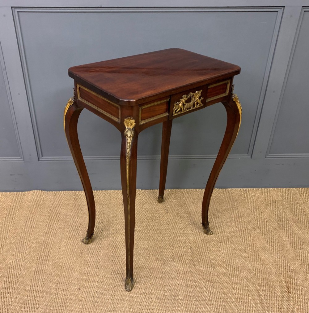 A rectangular dark mahogany side table featuring slender cabriole legs, gilt bronze corner mounts, and a decorative ormolu relief plaque on the frieze.