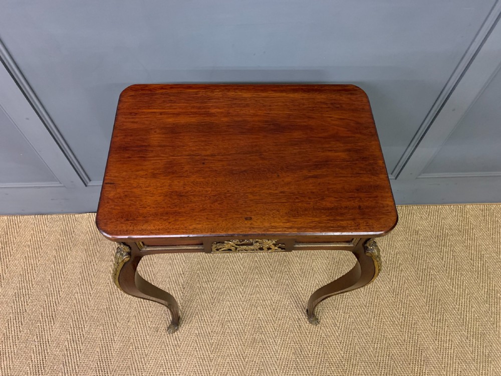 A rectangular dark mahogany side table featuring slender cabriole legs, gilt bronze corner mounts, and a decorative ormolu relief plaque on the frieze. View IV