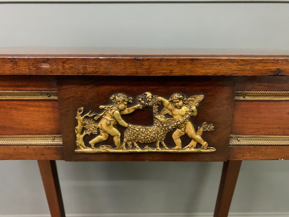A rectangular dark mahogany side table featuring slender cabriole legs, gilt bronze corner mounts, and a decorative ormolu relief plaque on the frieze. View V