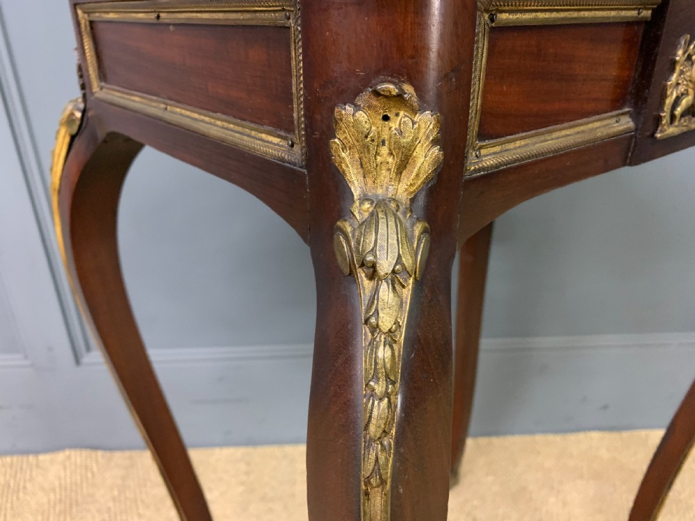 A rectangular dark mahogany side table featuring slender cabriole legs, gilt bronze corner mounts, and a decorative ormolu relief plaque on the frieze. View VII