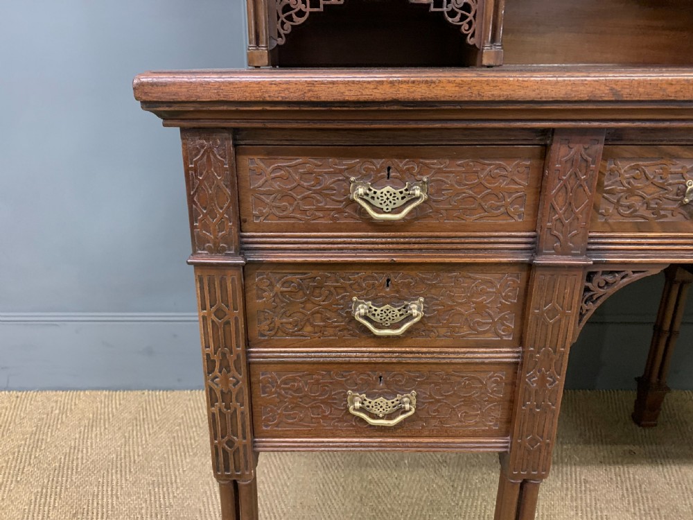 Victorian mahogany writing desk featuring a gallery superstructure with pierced fretwork, a brown leather inset surface, and multiple drawers with brass drop handles. View III