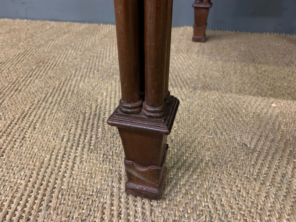 Victorian mahogany writing desk featuring a gallery superstructure with pierced fretwork, a brown leather inset surface, and multiple drawers with brass drop handles. View V