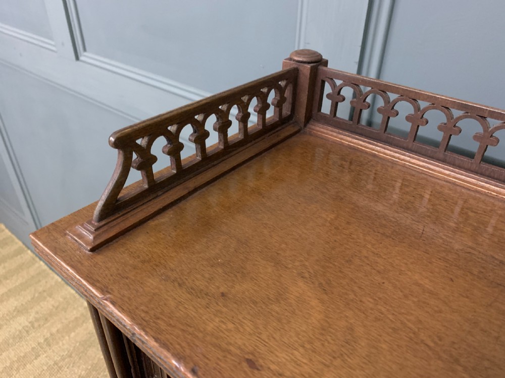 Victorian mahogany writing desk featuring a gallery superstructure with pierced fretwork, a brown leather inset surface, and multiple drawers with brass drop handles. View XI