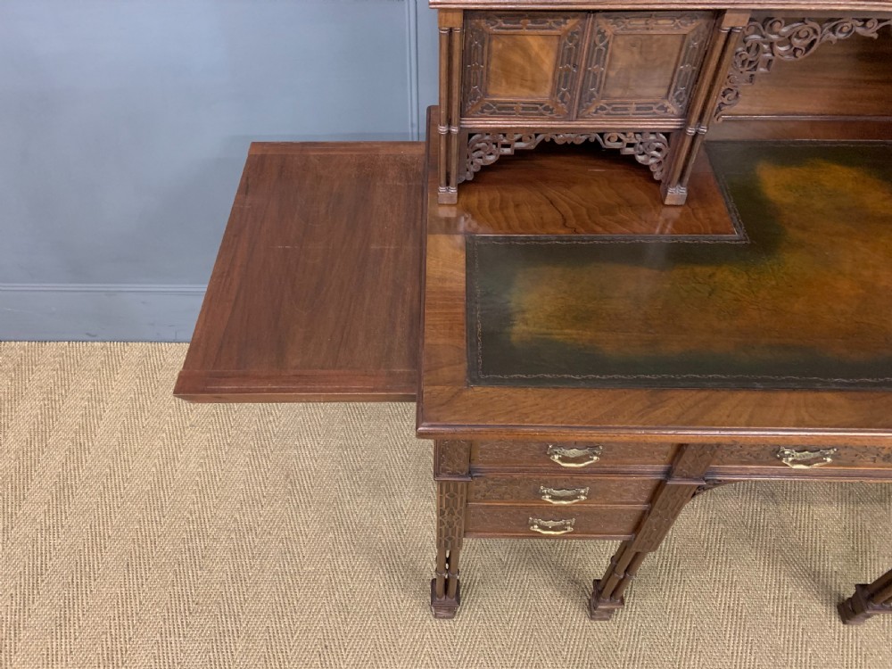 Victorian mahogany writing desk featuring a gallery superstructure with pierced fretwork, a brown leather inset surface, and multiple drawers with brass drop handles. View XVIII