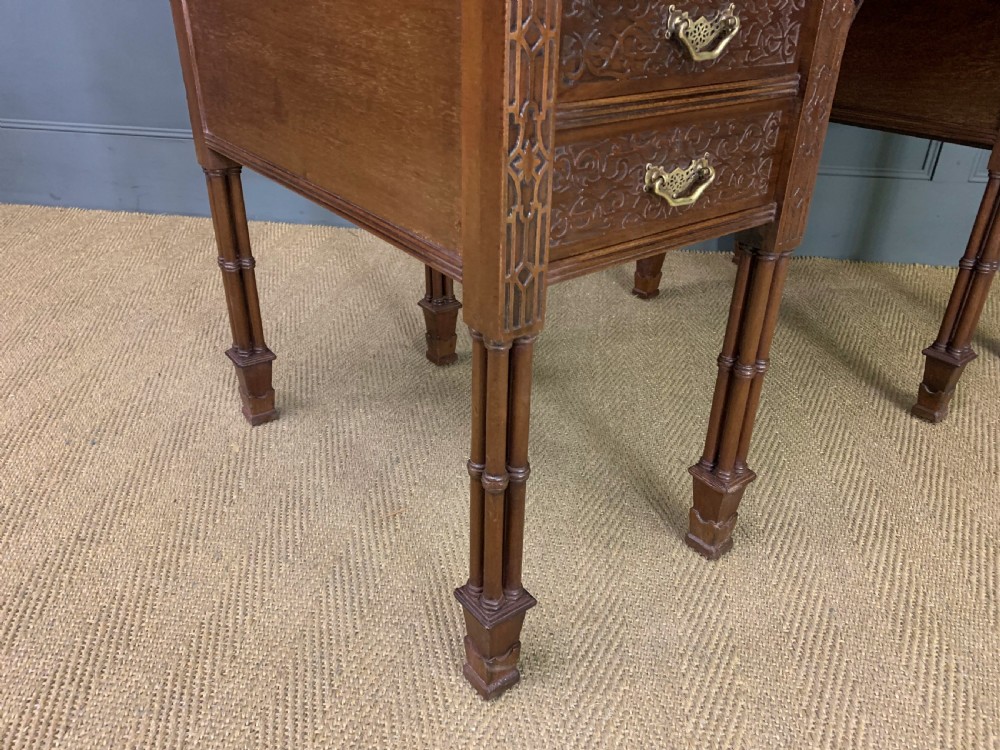 Victorian mahogany writing desk featuring a gallery superstructure with pierced fretwork, a brown leather inset surface, and multiple drawers with brass drop handles. View XXI