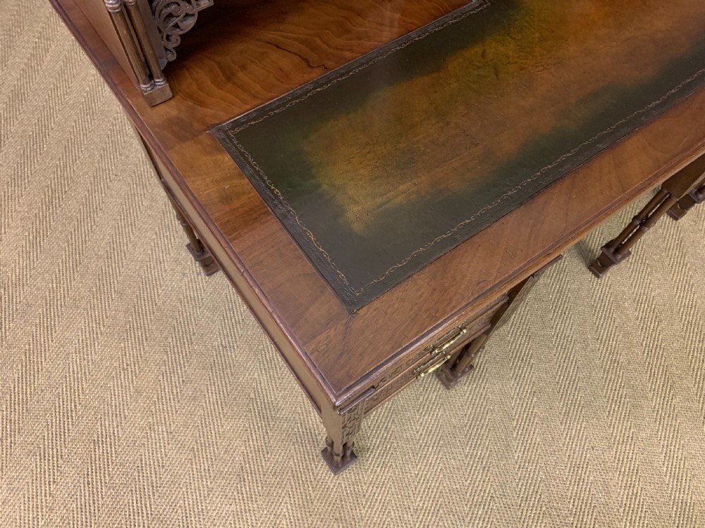 Victorian mahogany writing desk featuring a gallery superstructure with pierced fretwork, a brown leather inset surface, and multiple drawers with brass drop handles. View XXIII
