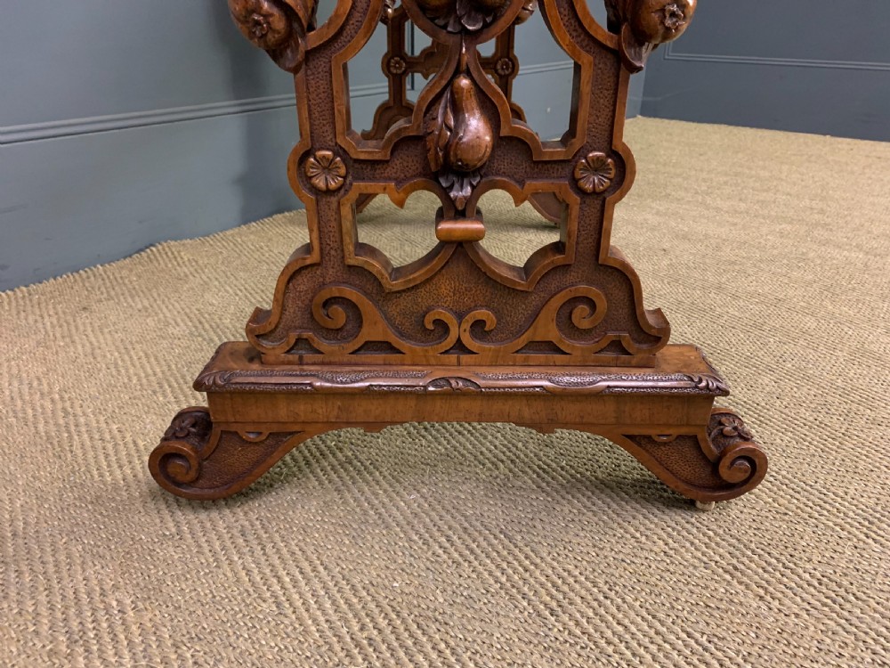 An antique Victorian rectangular table crafted from figured burr walnut veneer with intricately carved trestle supports. View VII