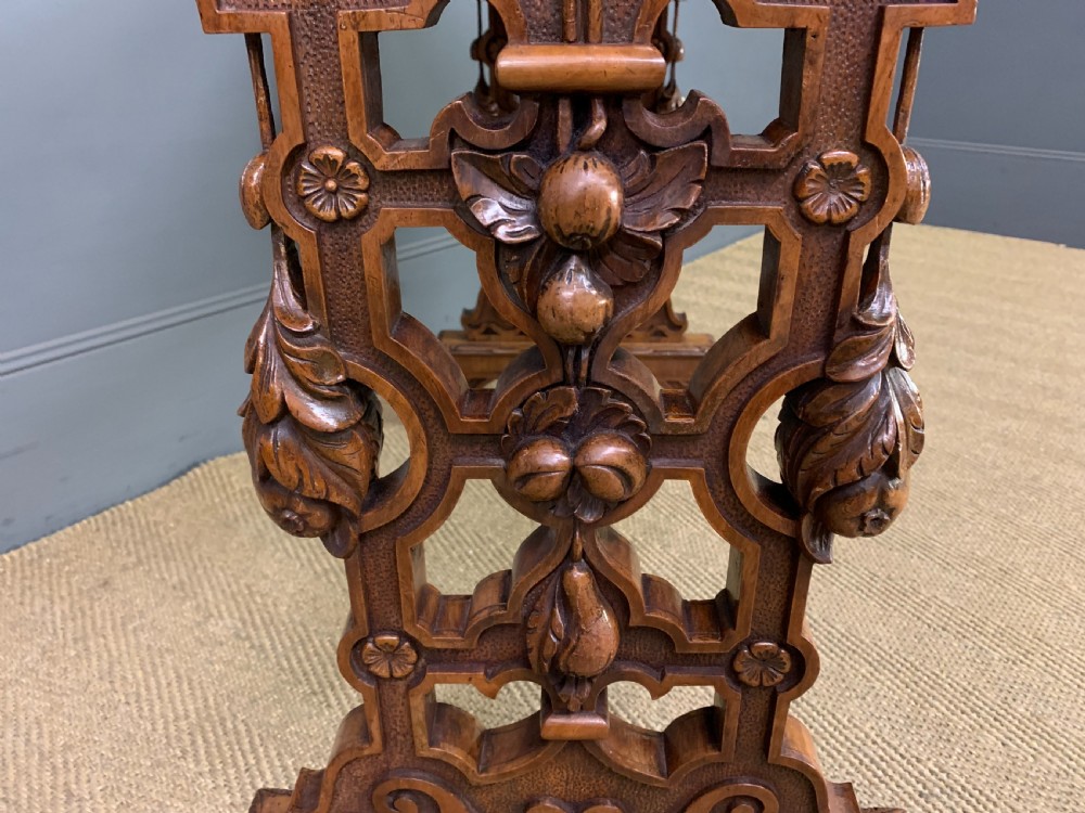 An antique Victorian rectangular table crafted from figured burr walnut veneer with intricately carved trestle supports. View VIII