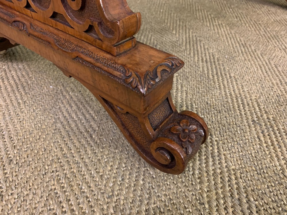 An antique Victorian rectangular table crafted from figured burr walnut veneer with intricately carved trestle supports. View IX