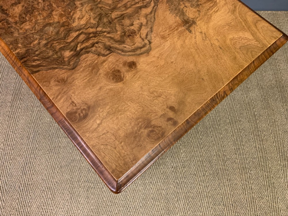 An antique Victorian rectangular table crafted from figured burr walnut veneer with intricately carved trestle supports. View XI