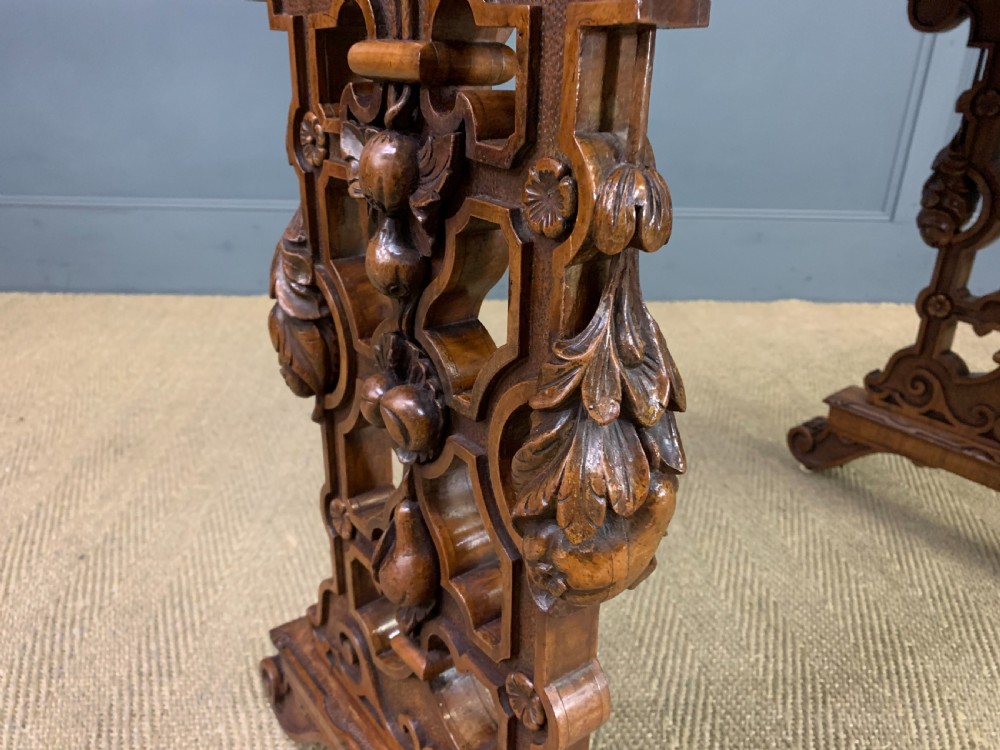 An antique Victorian rectangular table crafted from figured burr walnut veneer with intricately carved trestle supports. View XII