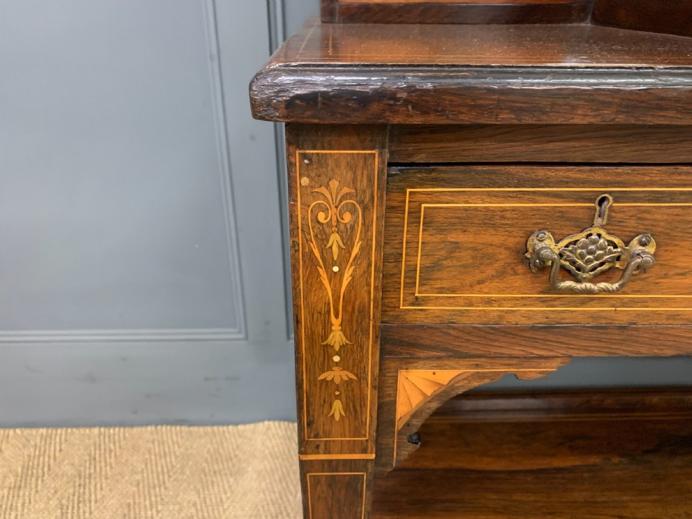 An antique rosewood bonheur du jour writing desk featuring intricate marquetry inlays, a central mirror, green leather writing top, and tapered legs on brass castors. View XI