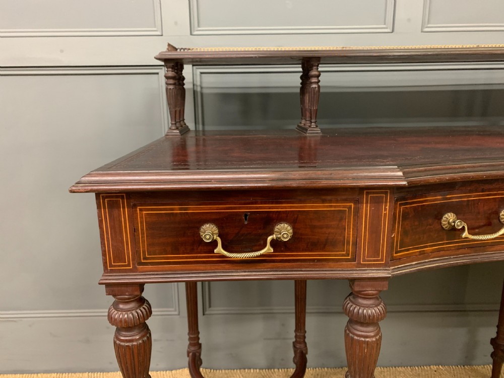 A late Victorian mahogany writing desk by Collinson and Lock with a raised upper shelf gallery, leather top, satinwood inlay, and turned legs. View V