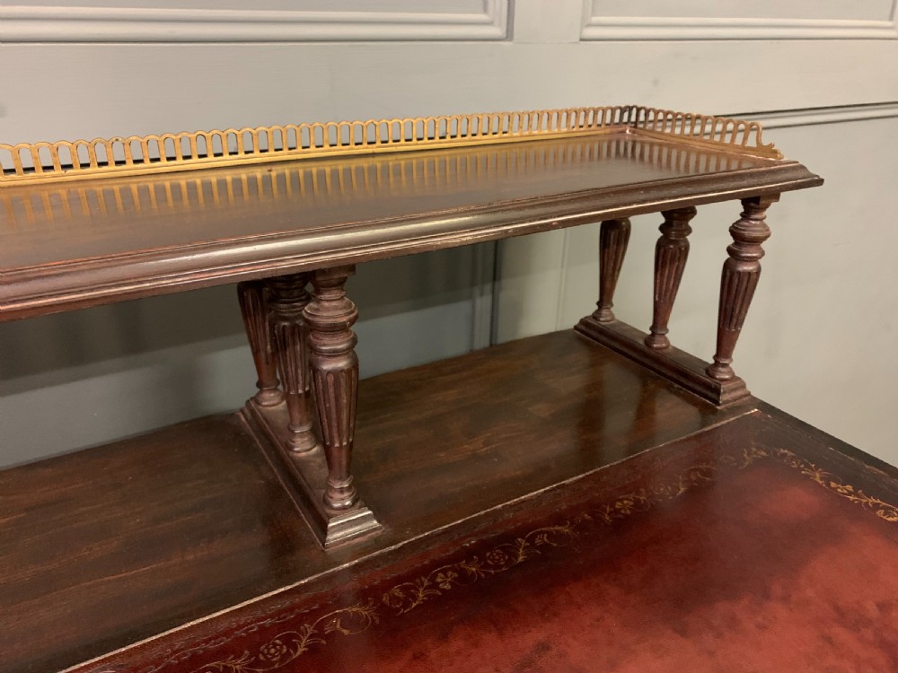 A late Victorian mahogany writing desk by Collinson and Lock with a raised upper shelf gallery, leather top, satinwood inlay, and turned legs. View VII