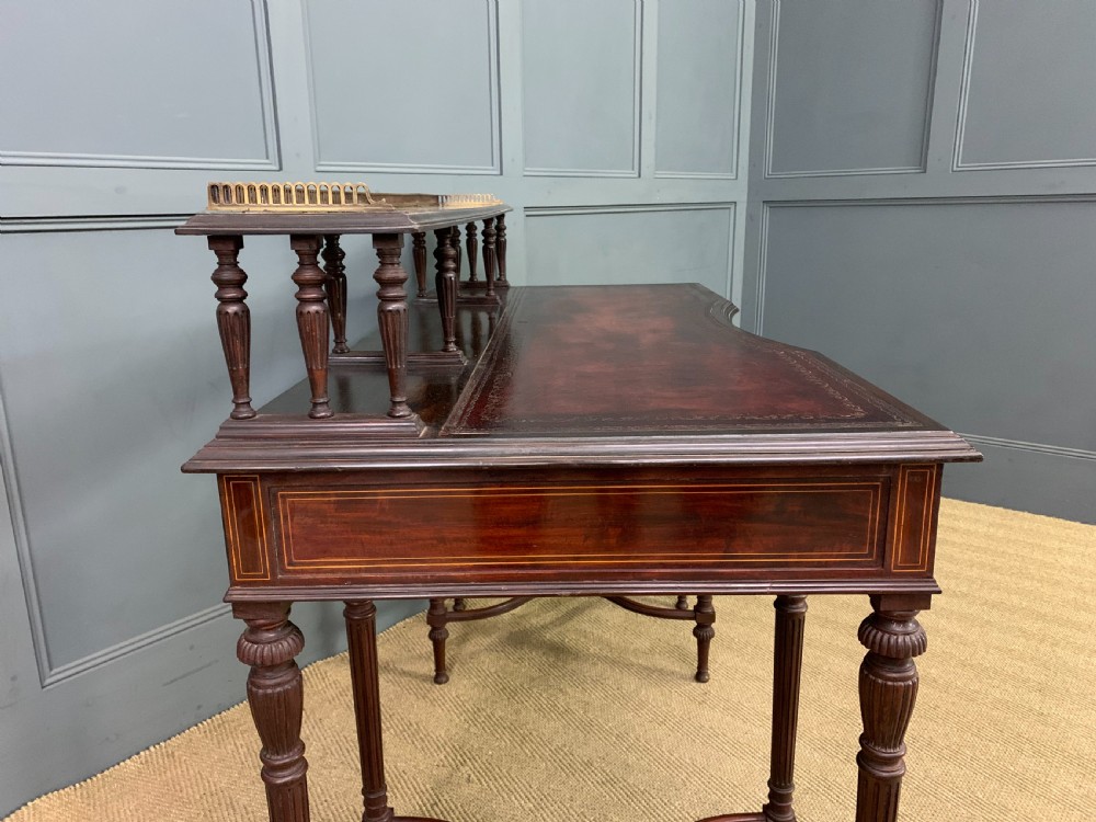 A late Victorian mahogany writing desk by Collinson and Lock with a raised upper shelf gallery, leather top, satinwood inlay, and turned legs. View XII