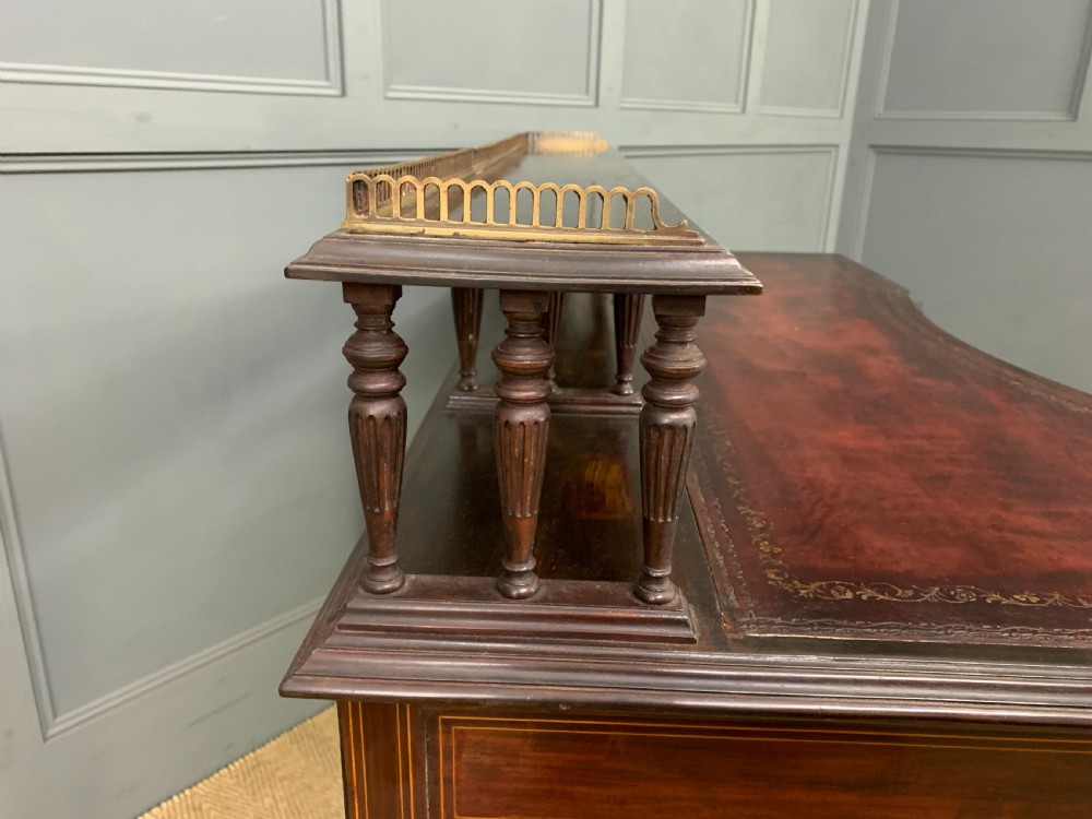 A late Victorian mahogany writing desk by Collinson and Lock with a raised upper shelf gallery, leather top, satinwood inlay, and turned legs. View XIII