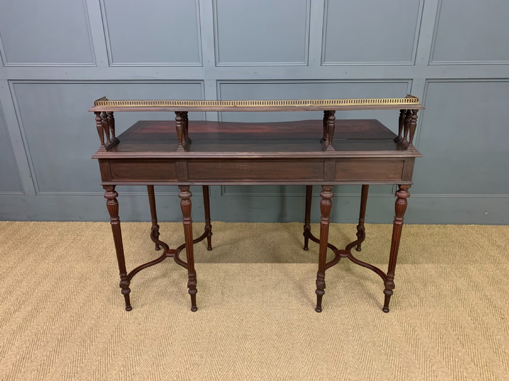 A late Victorian mahogany writing desk by Collinson and Lock with a raised upper shelf gallery, leather top, satinwood inlay, and turned legs. View XVIII