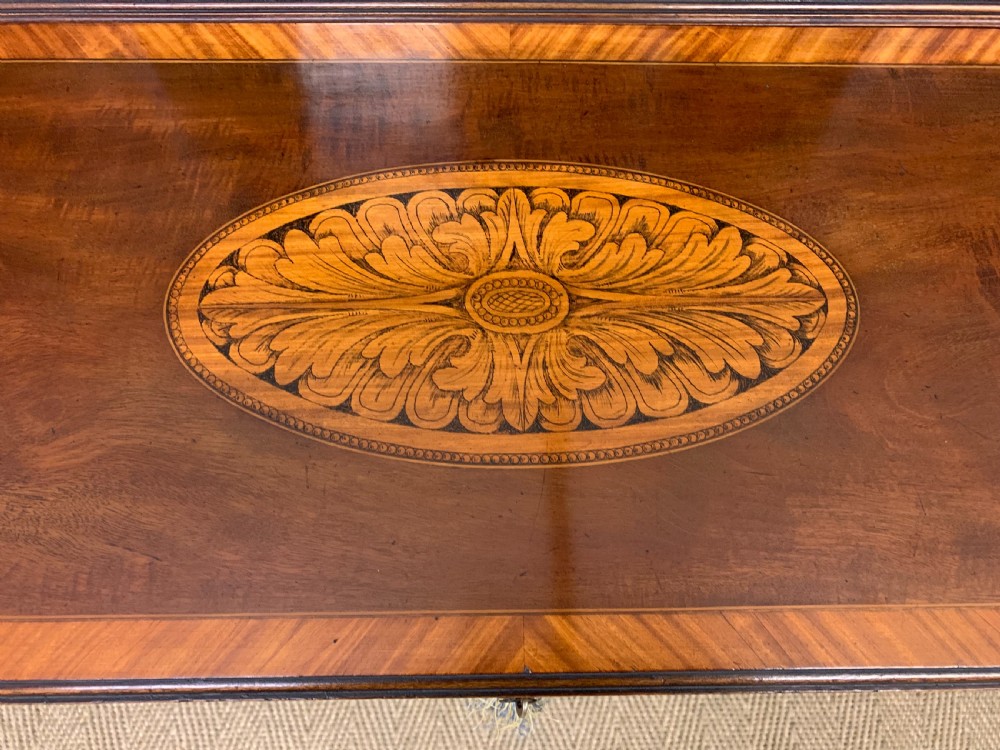 An Edwardian inlaid mahogany bonheur du jour writing desk featuring a central arched mirror, twin side cabinets with oval marquetry, brass galleries, and a lower shelf over tapered legs. View X