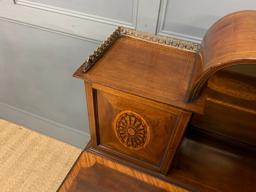An Edwardian inlaid mahogany bonheur du jour writing desk featuring a central arched mirror, twin side cabinets with oval marquetry, brass galleries, and a lower shelf over tapered legs. View XIII