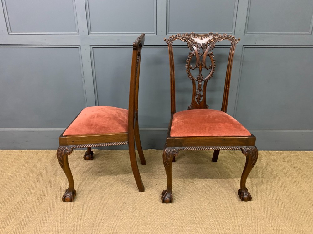 A pair of Chippendale style mahogany side chairs featuring intricate pierced back splats, cabriole legs with ball and claw feet, and terracotta velvet upholstered seats. View VI