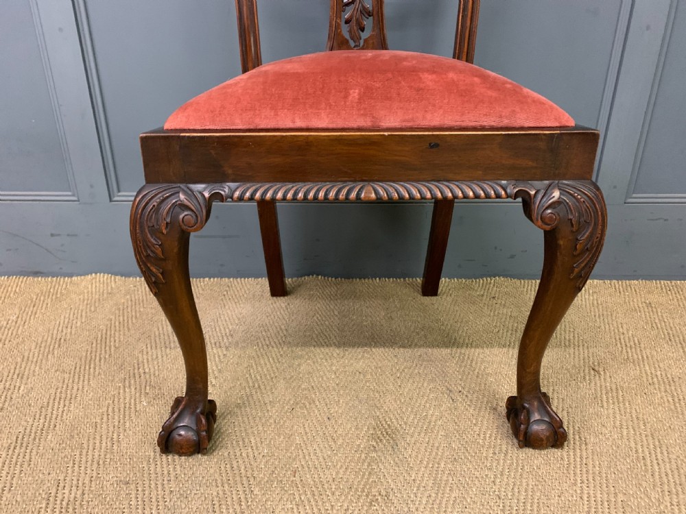 A pair of Chippendale style mahogany side chairs featuring intricate pierced back splats, cabriole legs with ball and claw feet, and terracotta velvet upholstered seats. View X