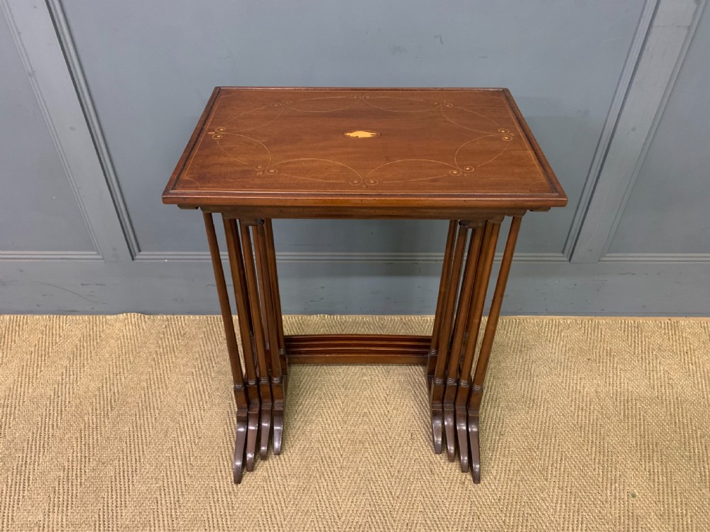A set of four graduating mahogany nest of tables featuring satinwood line inlay and slender turned legs. View II