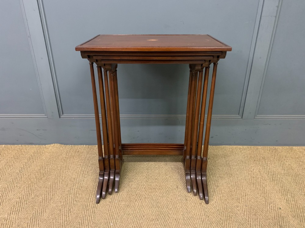 A set of four graduating mahogany nest of tables featuring satinwood line inlay and slender turned legs. View III