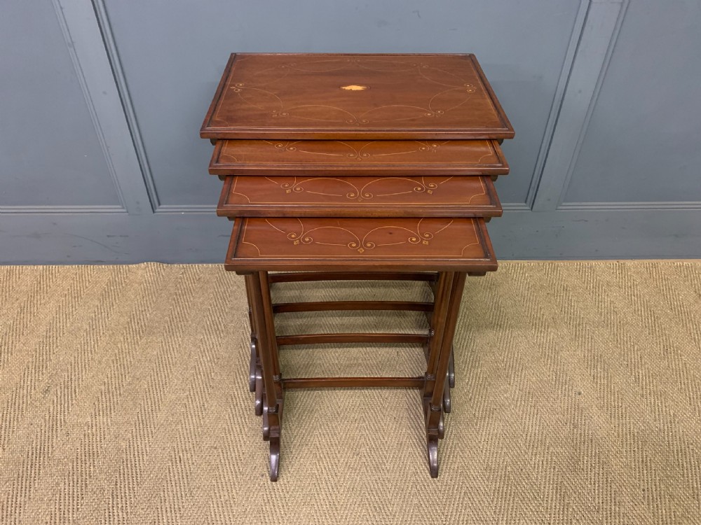 A set of four graduating mahogany nest of tables featuring satinwood line inlay and slender turned legs. View VI
