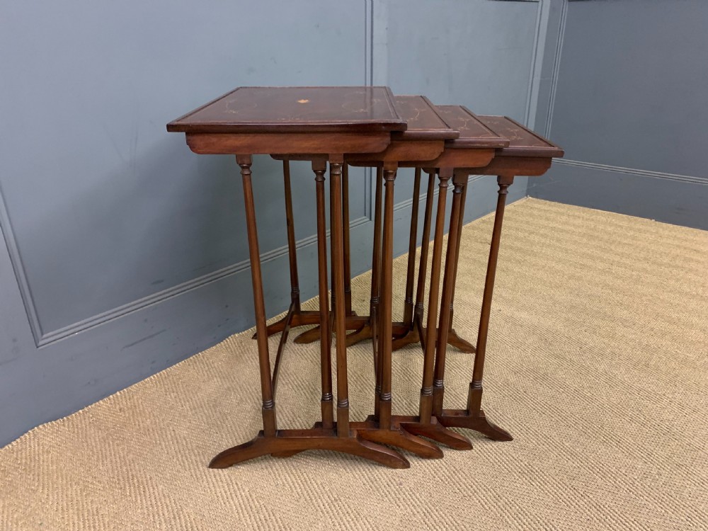 A set of four graduating mahogany nest of tables featuring satinwood line inlay and slender turned legs. View VII