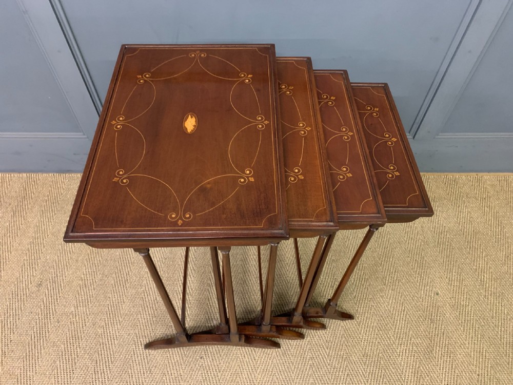 A set of four graduating mahogany nest of tables featuring satinwood line inlay and slender turned legs. View VIII