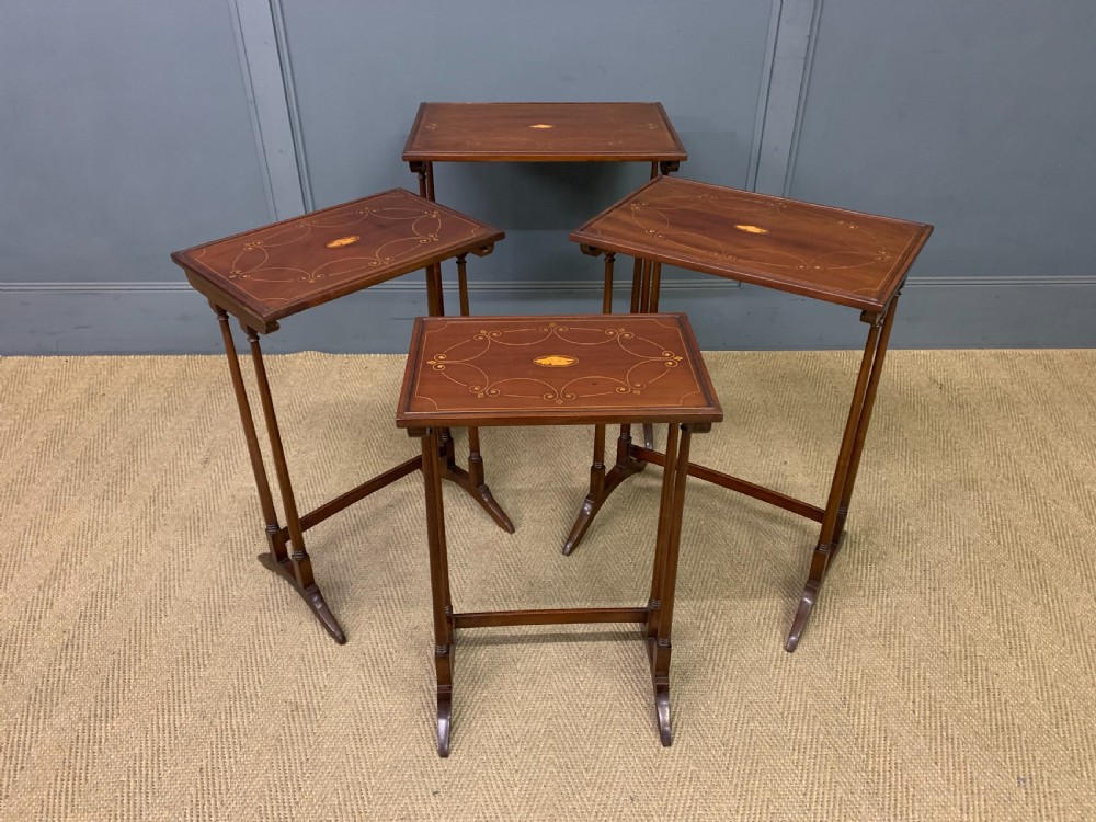 A set of four graduating mahogany nest of tables featuring satinwood line inlay and slender turned legs. View XI