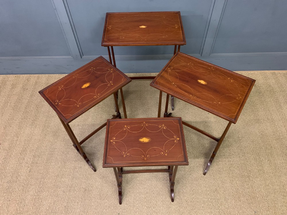 A set of four graduating mahogany nest of tables featuring satinwood line inlay and slender turned legs. View XII