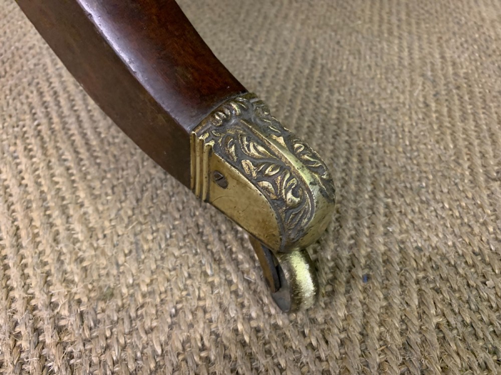 A George IV mahogany sofa table featuring two drawers with dark wooden knobs, drop-leaf side flaps, a turned central stretcher, and splayed legs on brass castors. View VIII