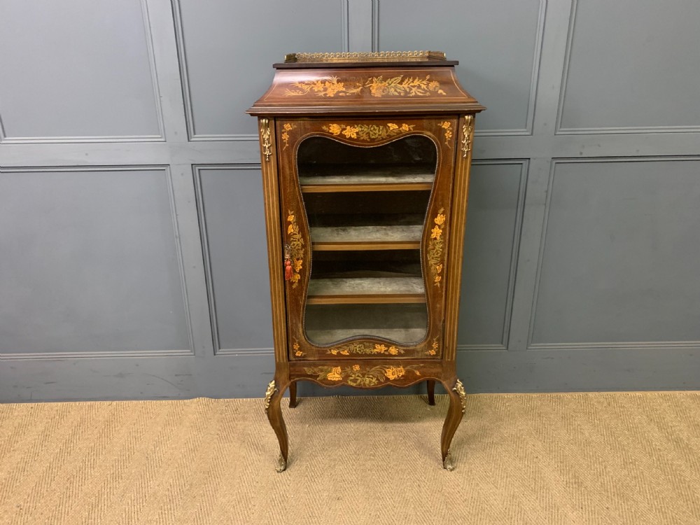 A freestanding mahogany vitrine featuring floral marquetry, a single glazed door, a brass top gallery, and cabriole legs with metal mounts. View II