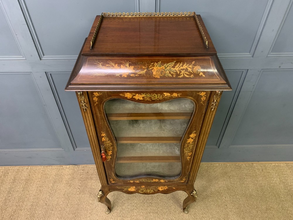 A freestanding mahogany vitrine featuring floral marquetry, a single glazed door, a brass top gallery, and cabriole legs with metal mounts. View III