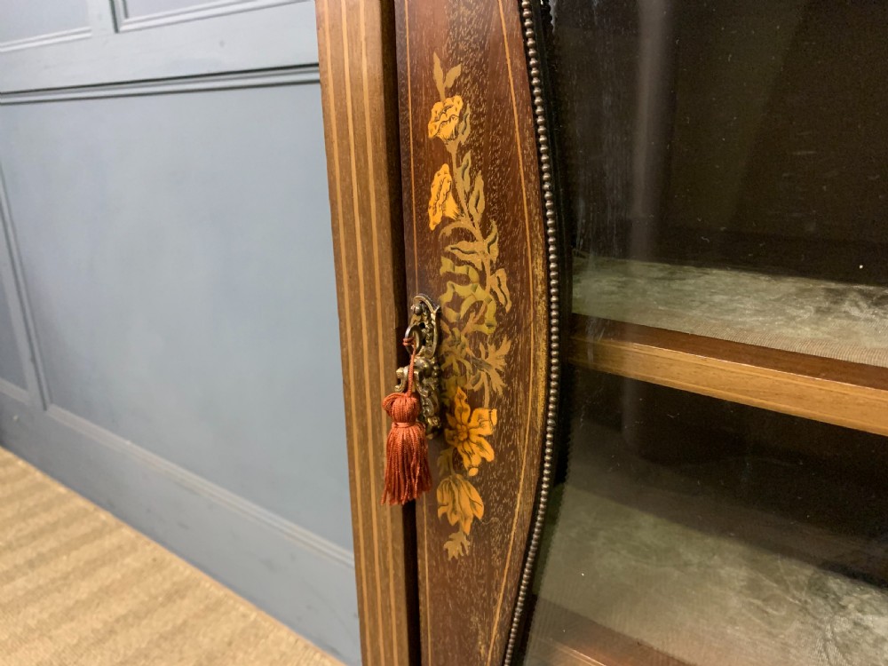 A freestanding mahogany vitrine featuring floral marquetry, a single glazed door, a brass top gallery, and cabriole legs with metal mounts. View X