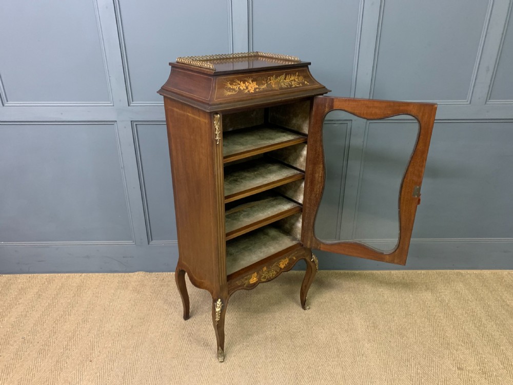 A freestanding mahogany vitrine featuring floral marquetry, a single glazed door, a brass top gallery, and cabriole legs with metal mounts. View XVI